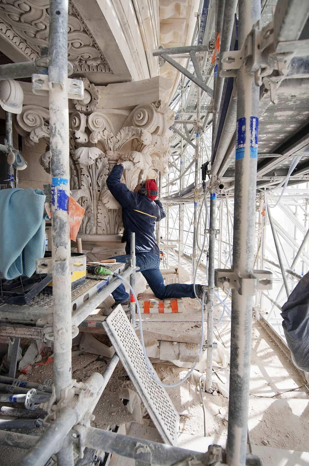 photographie corporate d'un tailleur de pierre en train de travailler sur les détails d'une colonne © francois nussbaumer