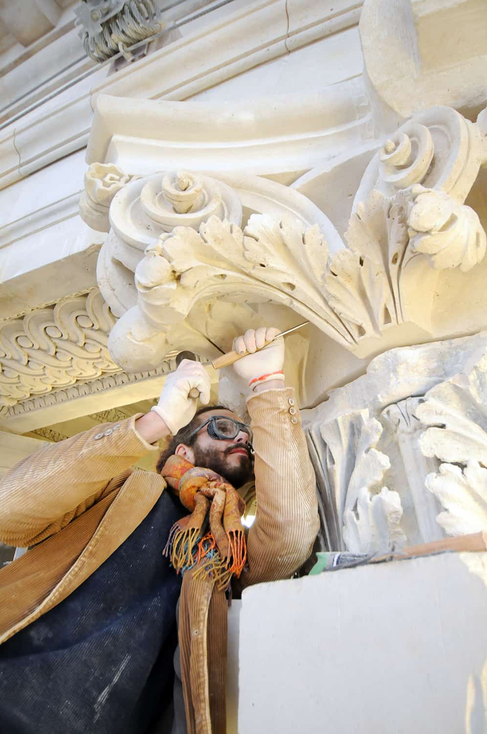 photographie corporate d'un tailleur de pierre sculptant une colonne avec un maillet © francois nussbaumer