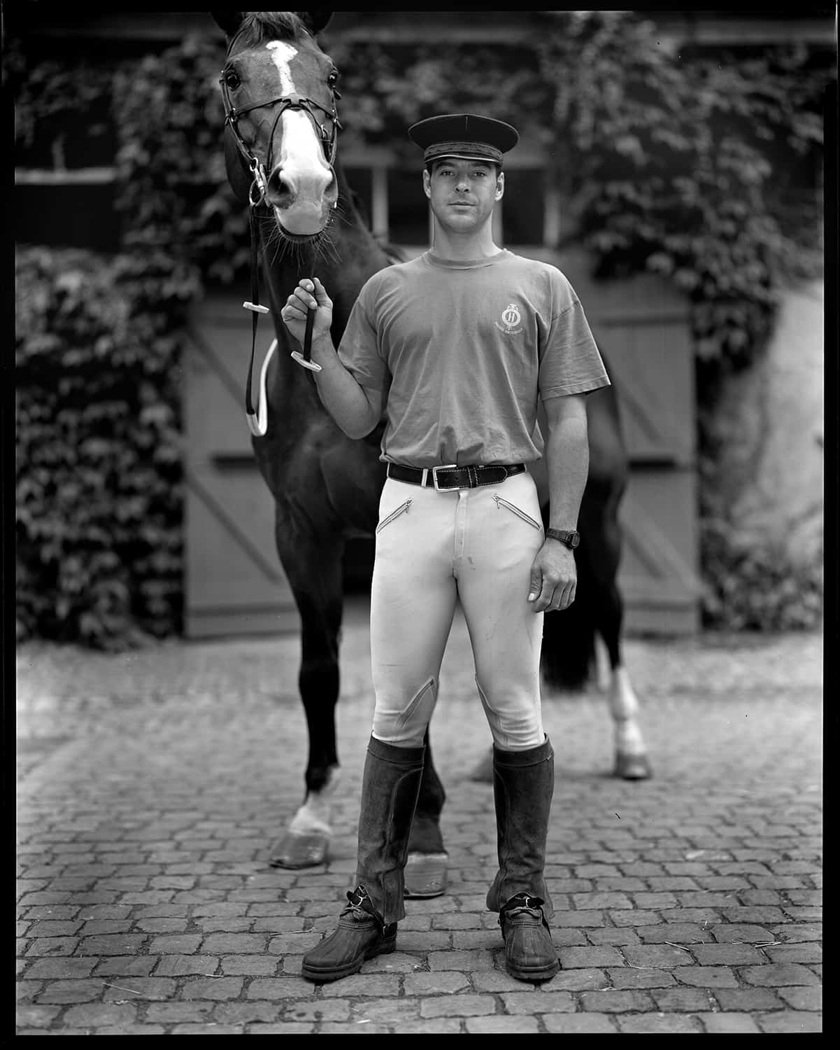 photo noir et blanc d'un employé de haras tenant un cheval © francois nussbaumer