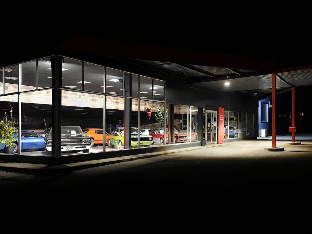 photographie de la vitrine d'un magasin automobile où sont exposées des voitures américaines © francois nussbaumer