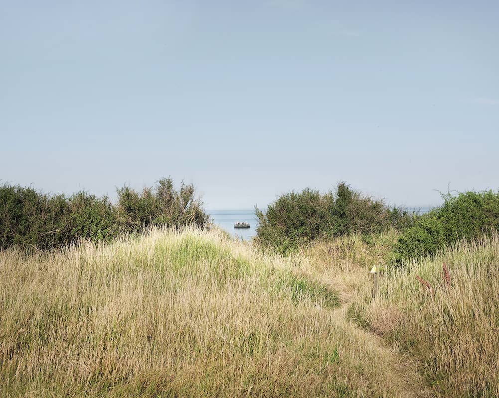 photographie d'un paysage de bord de mer avec un bateau sur la mer dans le fond © francois nussbaumer